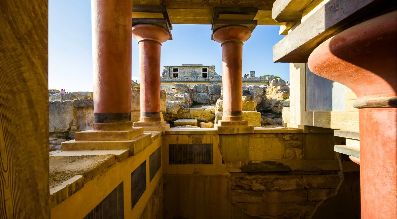 Red tapering Minoan columns and a large clay storage pithos in the residential quarter of Knossos