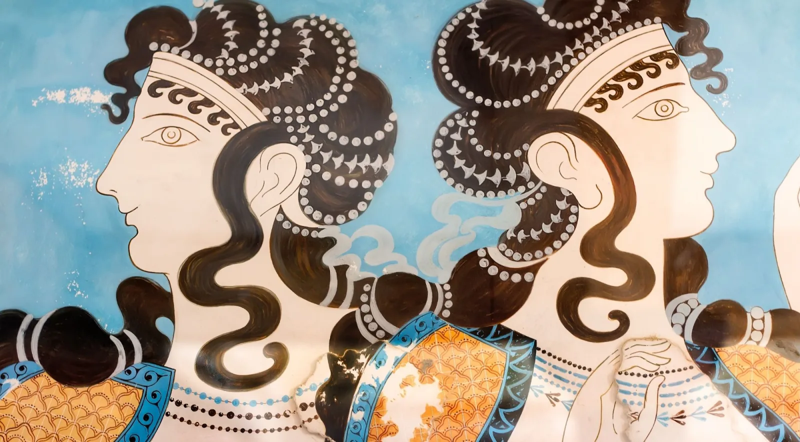 Detail of the Ladies in Blue fresco from Knossos, showing two women with elaborate dark curls and jewellery