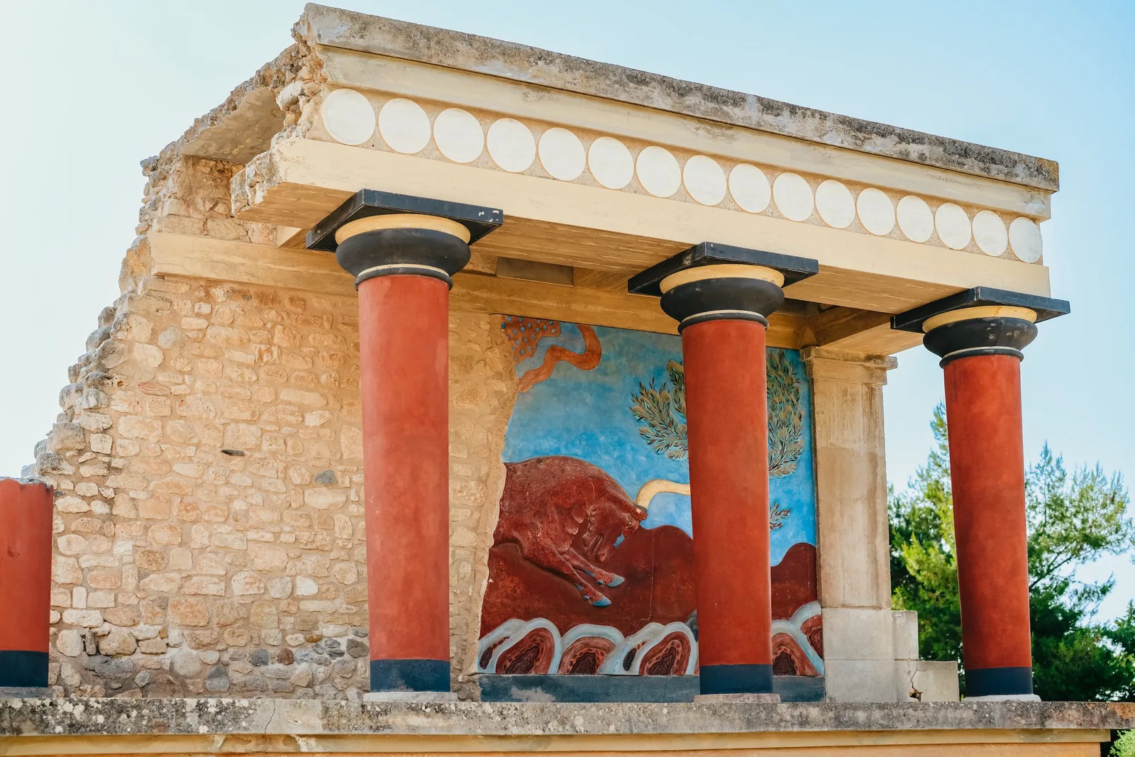 The North Entrance portico at Knossos, red columns beneath the charging-bull relief fresco