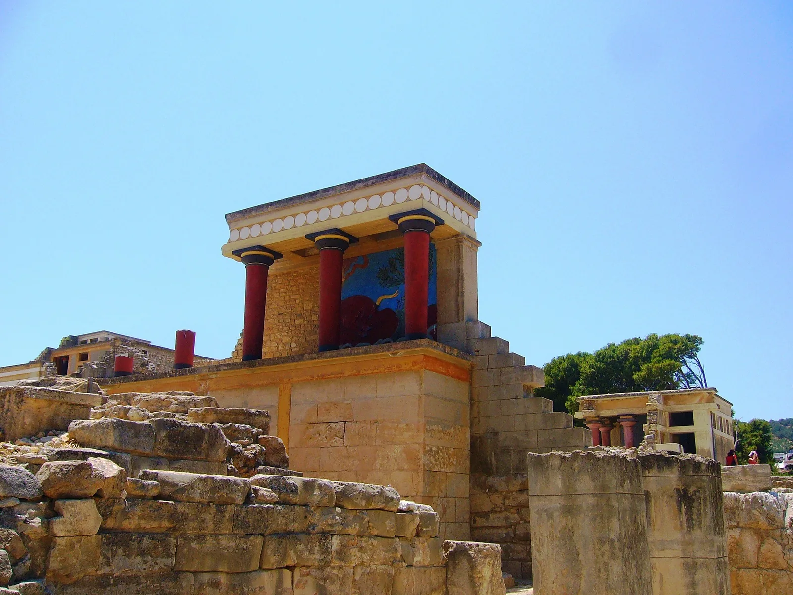 The restored palace facade at Knossos rising above excavated walls and low scrub