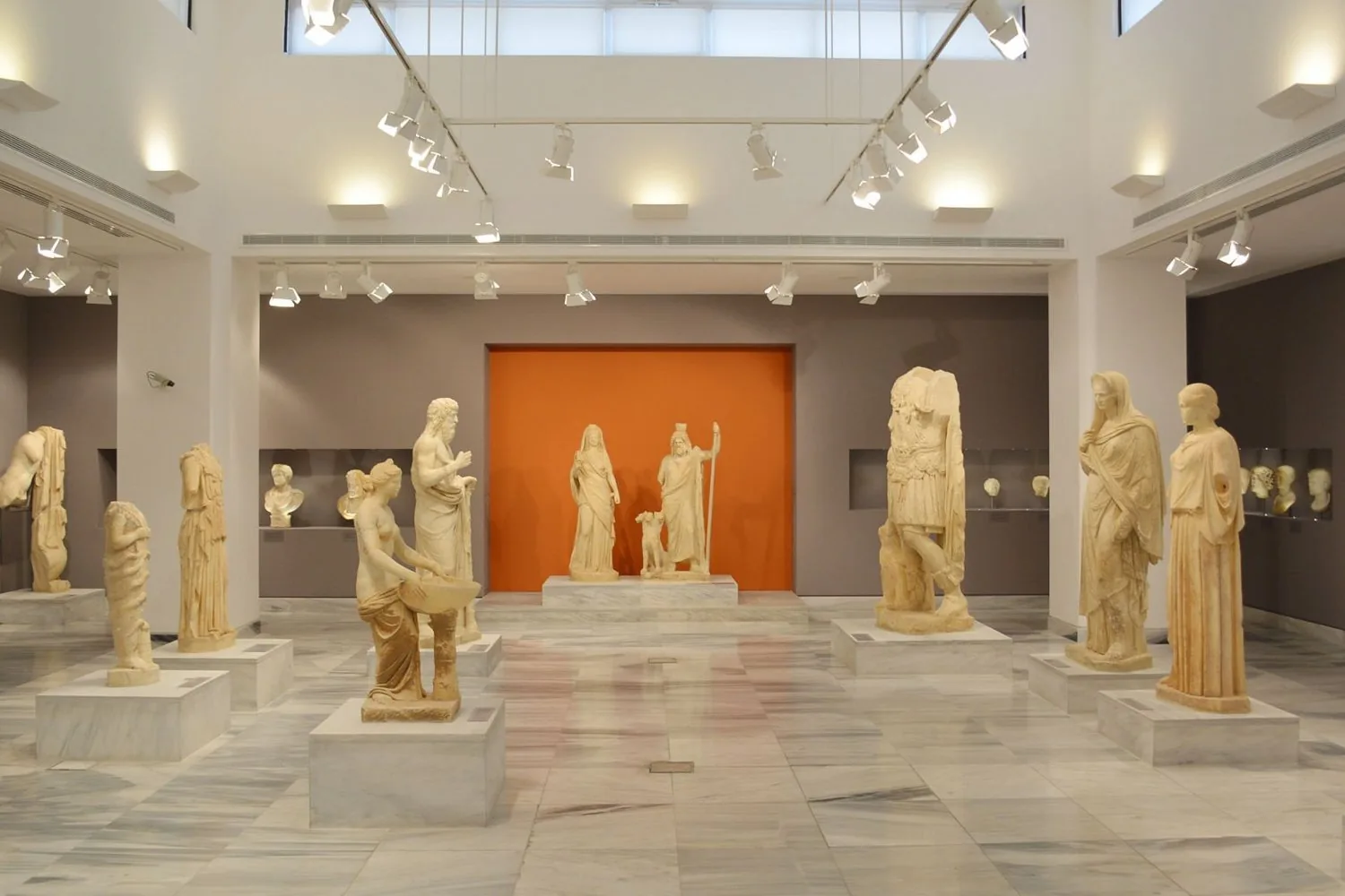 The sculpture gallery of the Heraklion Archaeological Museum, statues lit against pale walls